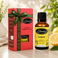 Lemon Essential Oil bottle with gift box, fresh lemons and green ribbon